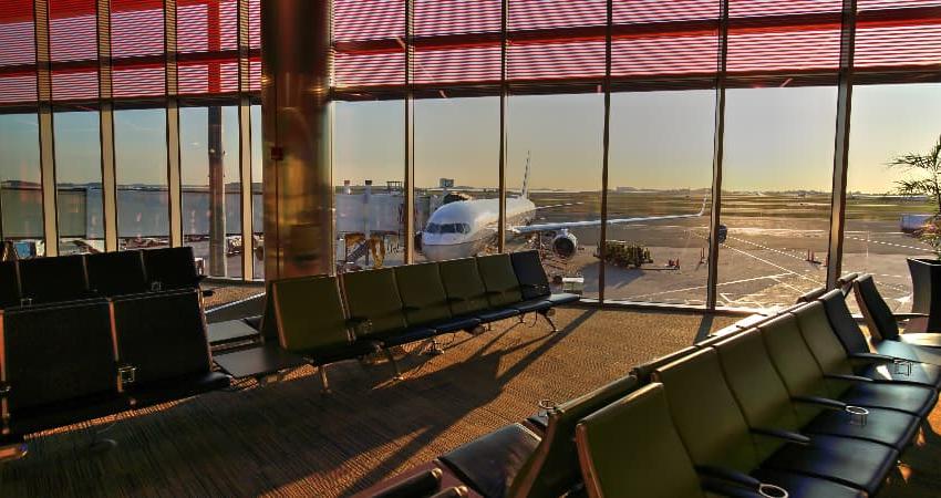 太阳从波士顿洛根国际机场的空门上升起, 从落地窗外可以看到一架客机